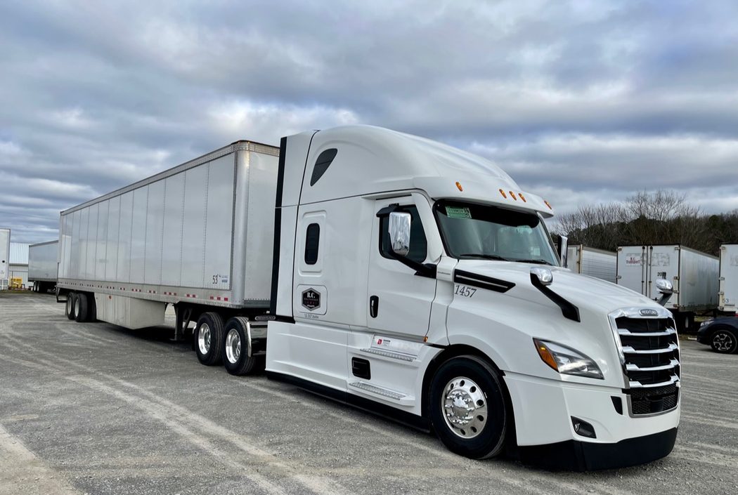 R.C. Transport white tractor and trailer under cloudy sky
