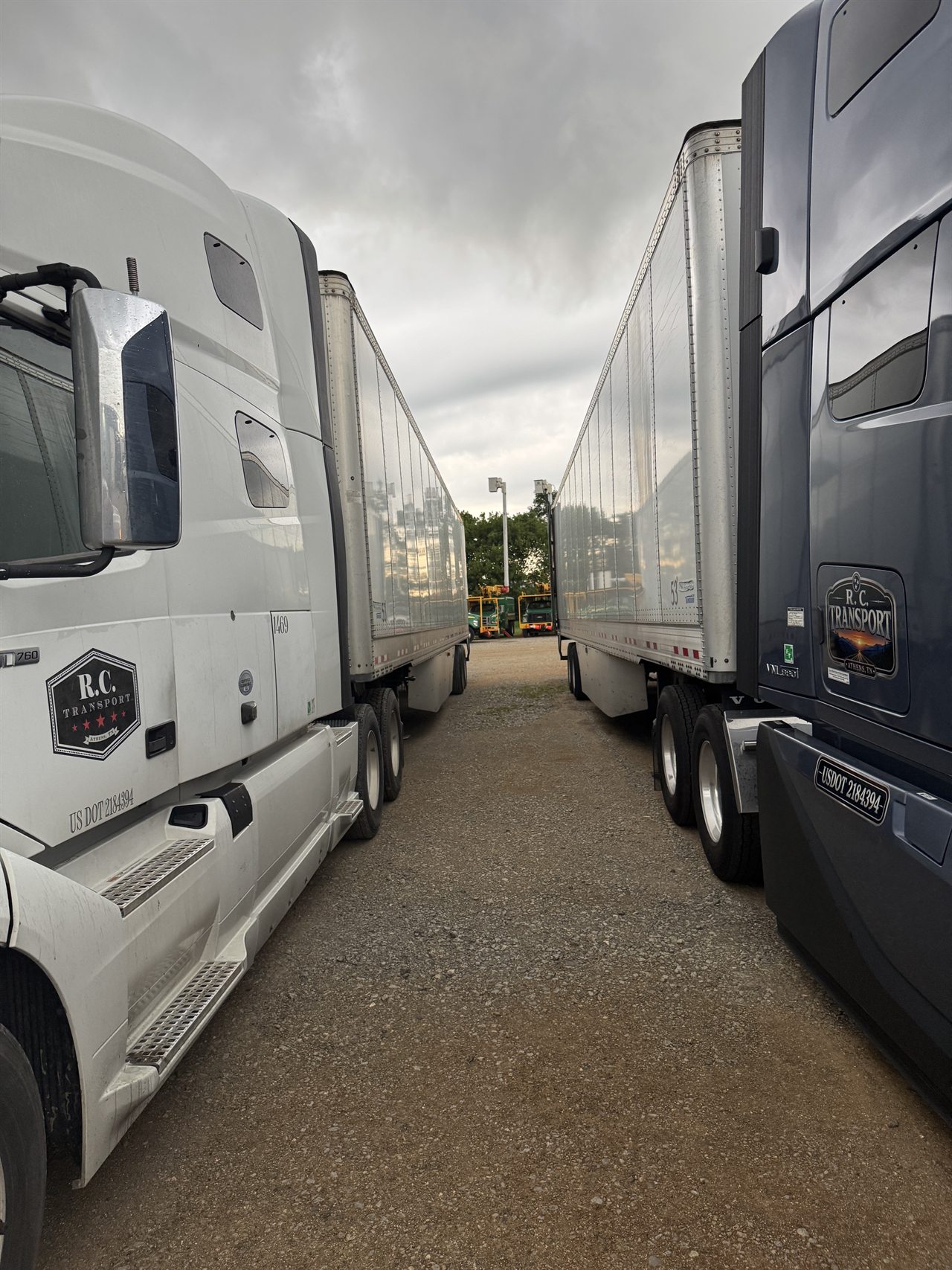 Two branded R.C. Transport tractors with dry van trailers in the Athens yard
